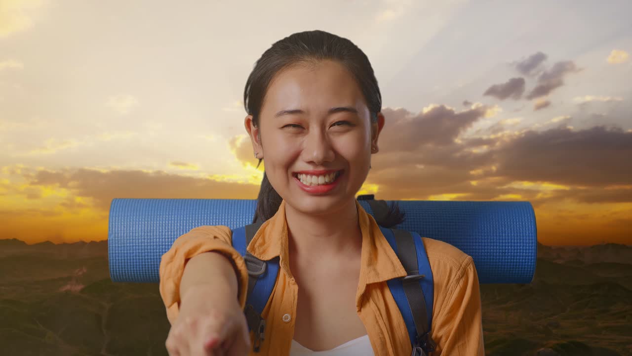 Close Up Of Asian Female Hiker With Mountaineering Backpack Smiling, Touching Her Chest, And Pointing To Camera While Standing On The Top Of Mountain During Sunset Time