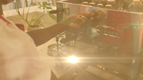 animation of lens flare and sunlight with hands of barista preparing coffee using machine