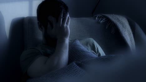 man in foreground sitting in an armchair in the gloomy twilight