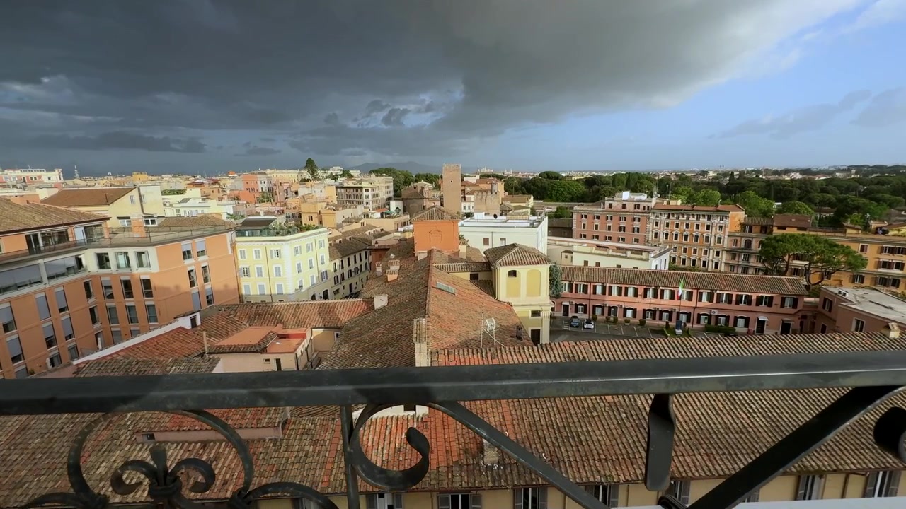 Godersi una vista serena da un balcone a Roma che si affaccia sui tetti e su un temporale in avvicinamento