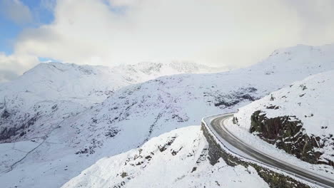 Aerial-footage-of-a-snow-covered-Pen-Y-Pass-road-in-Snowdonia,-Wales