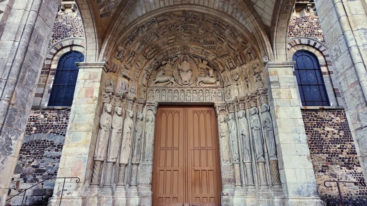 Entrance of Le Mans Cathedral, medieval stone sculptures and grand wooden doors, French Gothic architecture, France. First-person walking