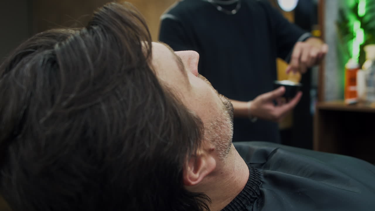 Mand, der bliver barberet i en barbersalon