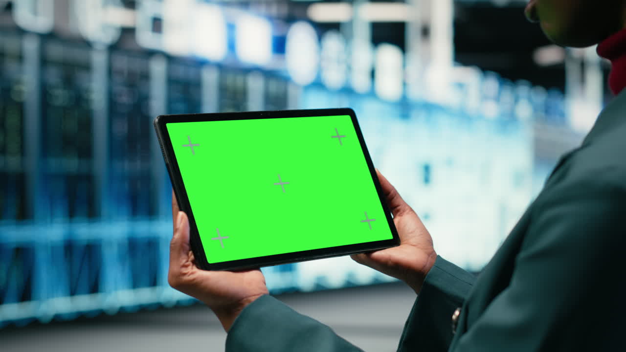 Person holder tablet med greenscreen i et datacenter.