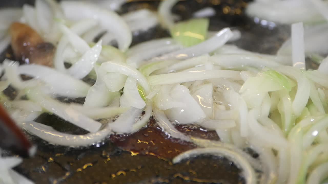 Frying sliced onions in a pan