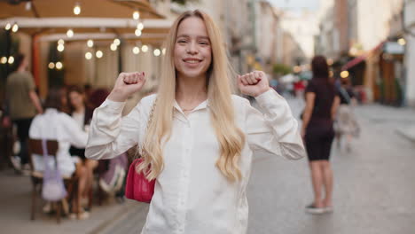 young woman shouting celebrating success winning goal achievement good victory news in city street