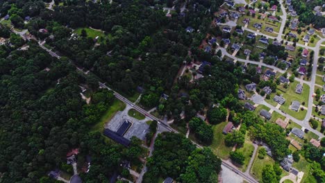 Aerial-birds-eye-shot-of-american-neighborhood-in-Stone-Mountain-City-with-green-trees-and-traffic-on-main-highway---top-down