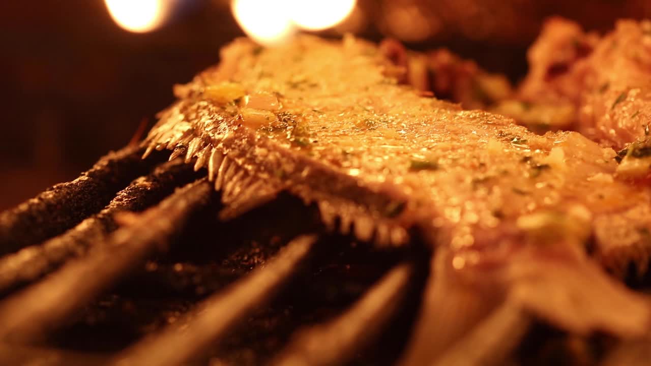 sonidos chisporroteantes y aromas tentadores llenan el aire mientras un delicioso plato de pescado se prepara expertamente en un horno de essaouira.