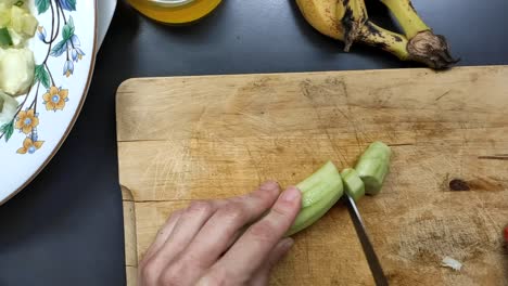 food preparation cutting cucumber on a wood surface for salad