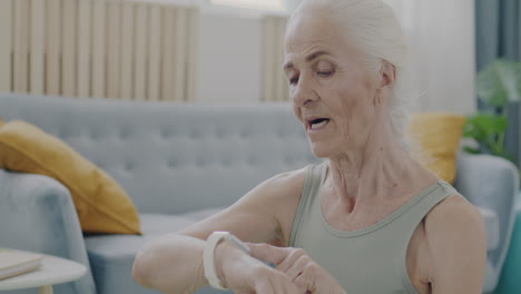 senior woman checking fitness watch at home