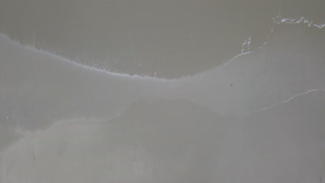 disparo cenital de drones volando directamente sobre las olas en la playa en playas general villamil, ecuador-1