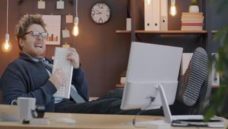 funny employee relaxing at desk with keyboard
