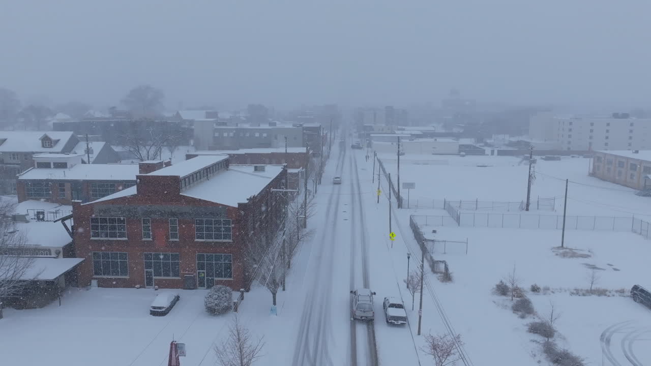 Aerial footage during a snowstorm in Chattanooga, TN that pans up to reveal a two way street leading to downtown.