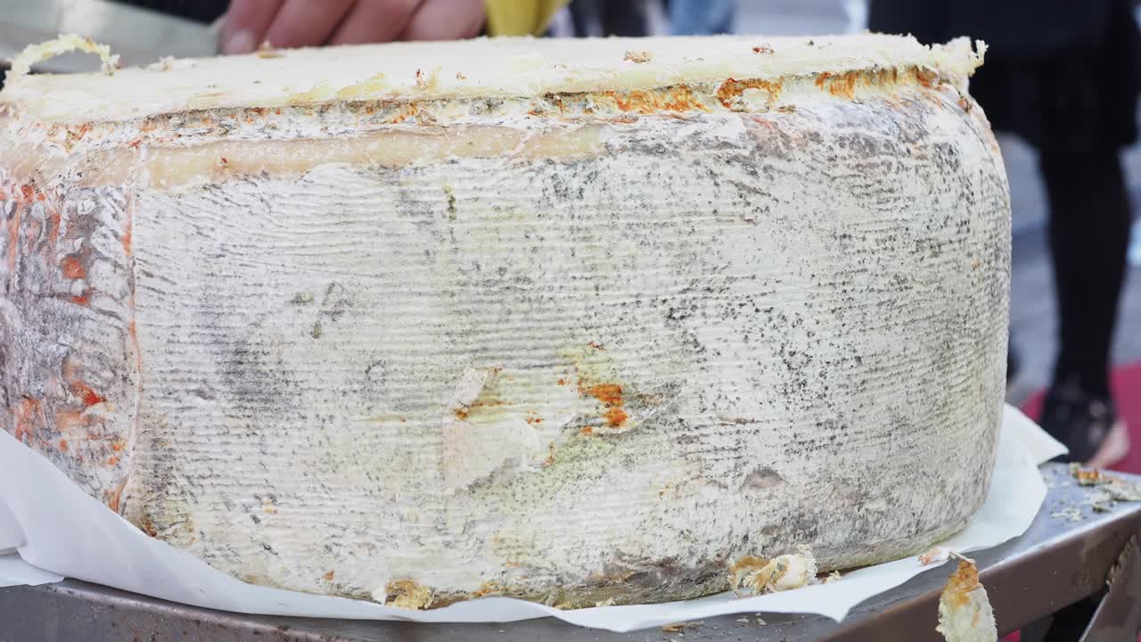 Primo piano di una forma di formaggio che viene tagliata