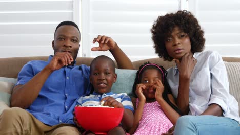 Family-sitting-on-sofa-and-watching-television