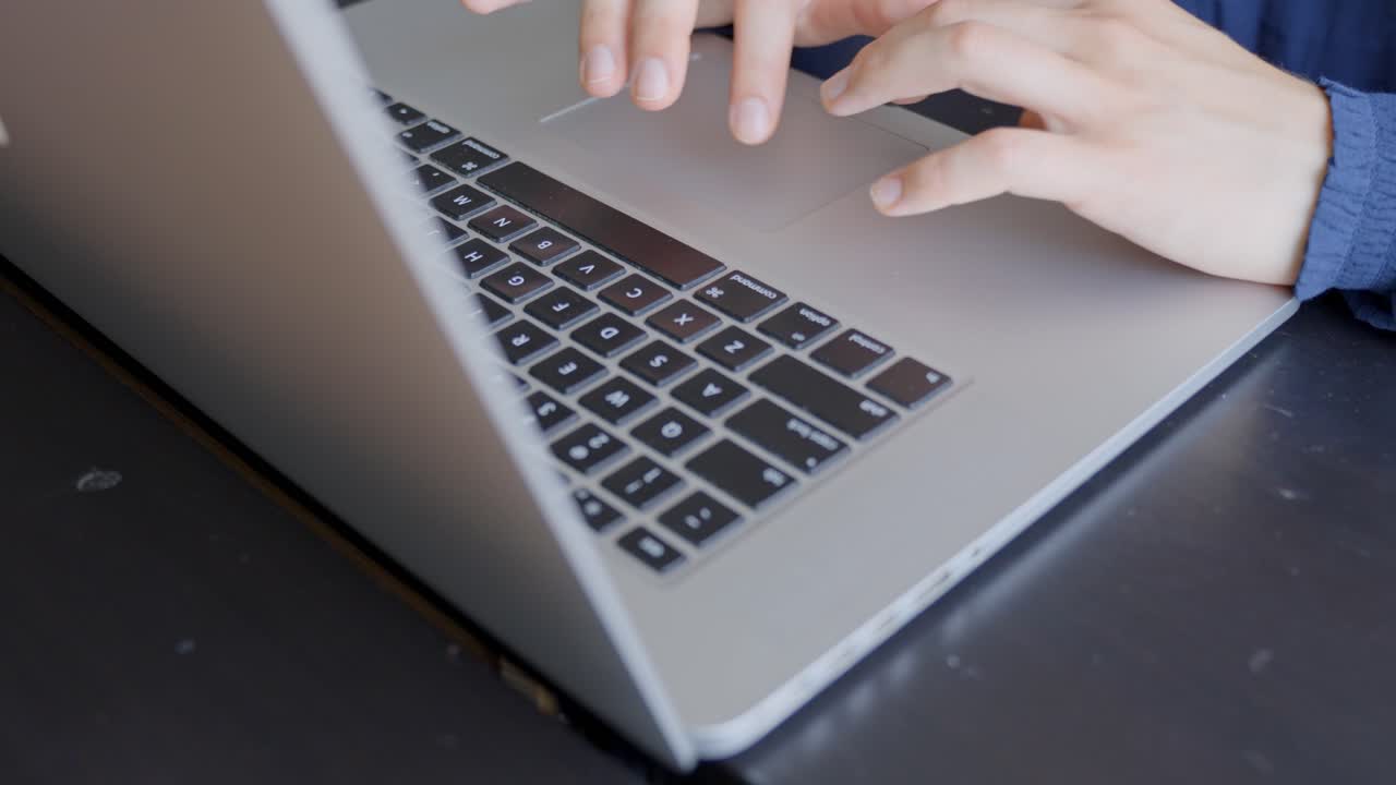 Woman hands typing keyboard of laptop computer, close up
