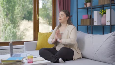 mujer joven en meditación frente a la ventana.