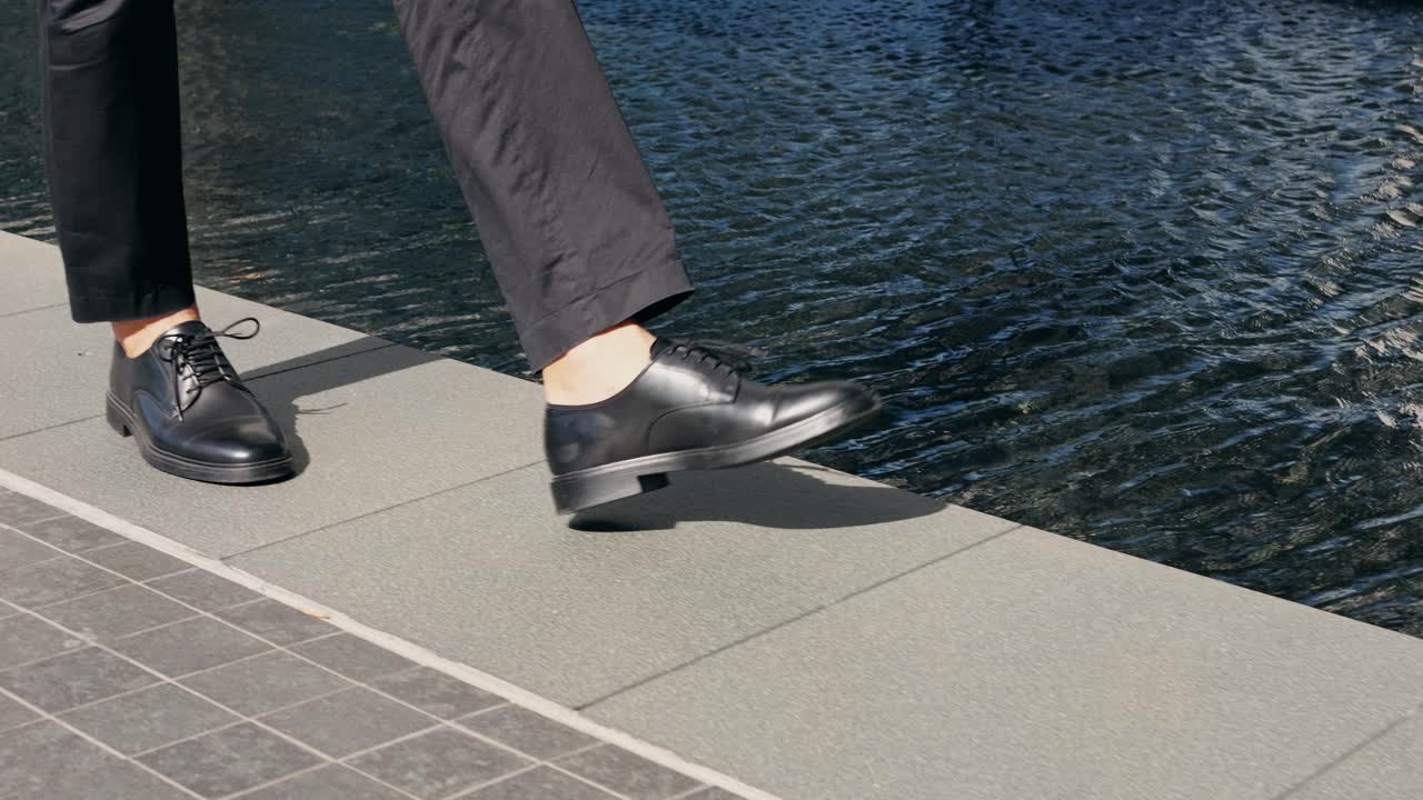 Black leather dress shoes on pavement