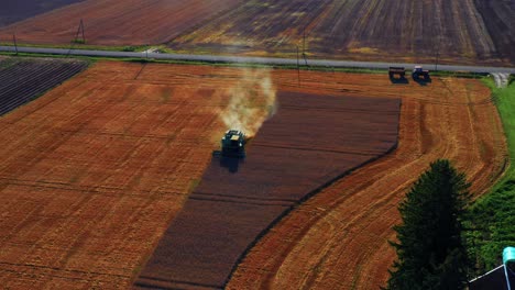 Vista-Aérea-De-La-Cosecha-Combinada-De-Cultivos-En-El-Campo-De-Trigo-Dorado-Durante-El-Día