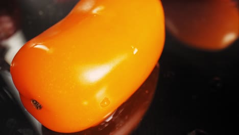 fresh cherry tomatoes on black surface, close up view, macro shot