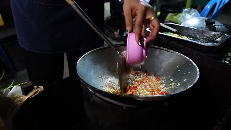 chef stir frying ingredients in a wok