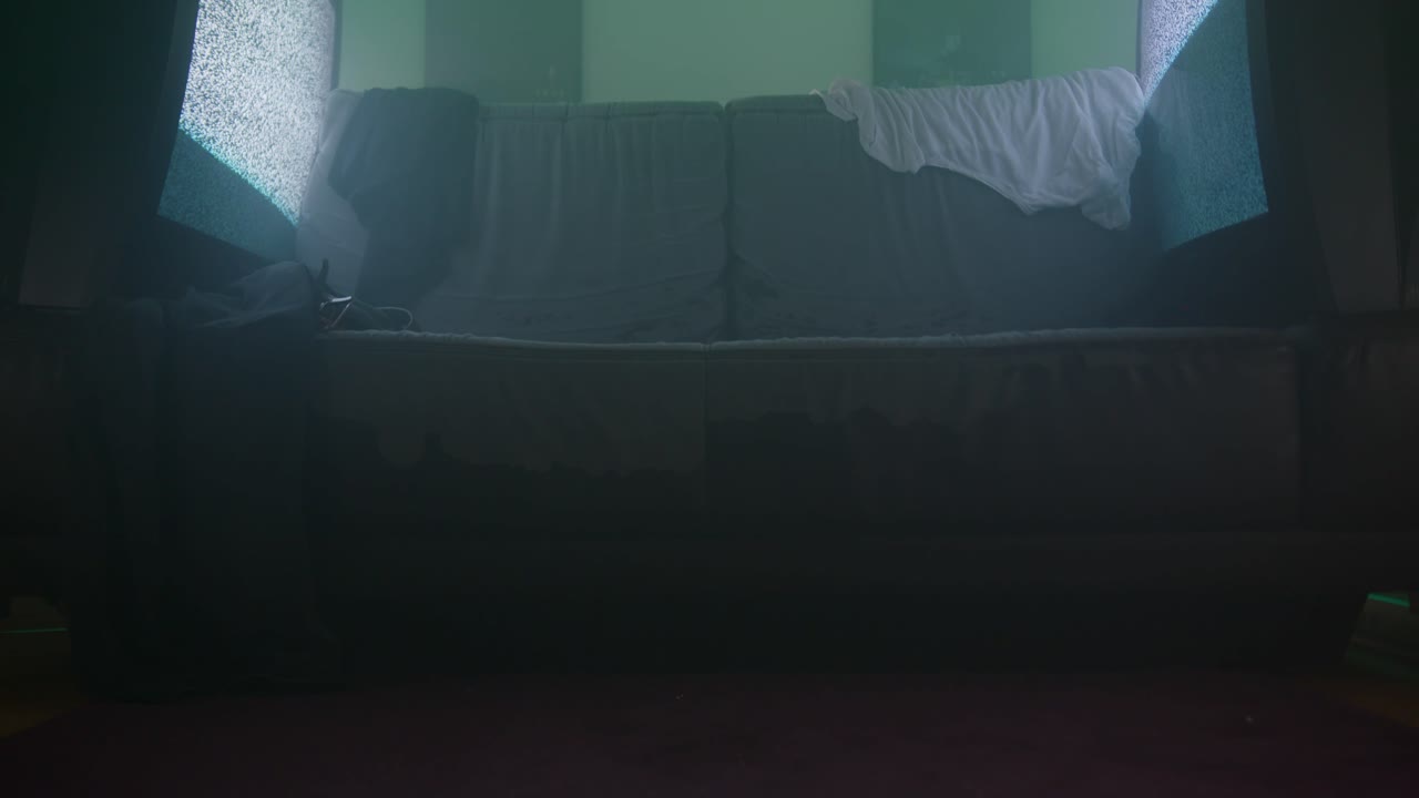 habitación desperdiciada con televisores parpadeantes