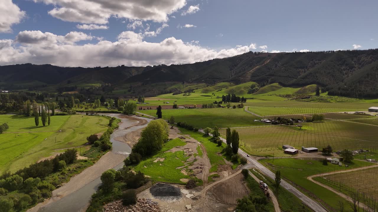 Fiume Motueka che scorre attraverso una valle verde con fattorie e vigneti nella regione di Tasman, Nuova Zelanda