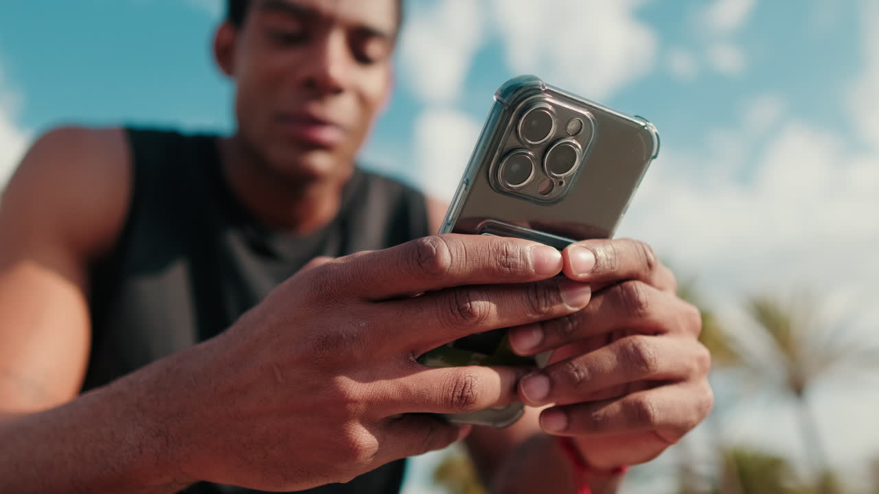 Young Athlete Using Phone After a Workout. Focus on the phone