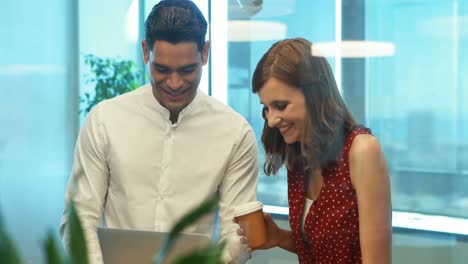 Business-colleagues-discussing-over-laptop