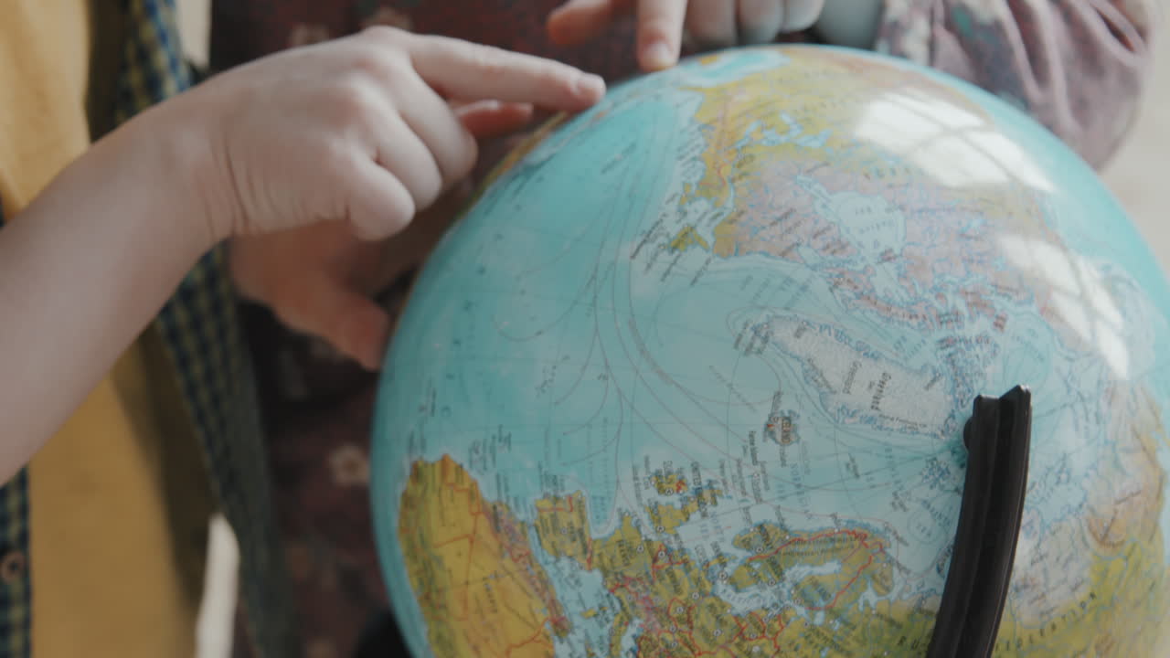 Unrecognizable Kids Using World Globe