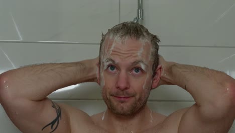 hombre caucásico de 36 años se puso jabón en el cabello y la cara, luego se lo lavó con la ducha.