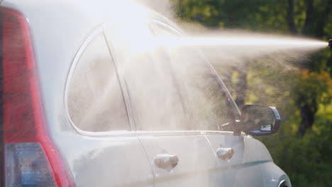 side view of a car washed with a high pressure washer