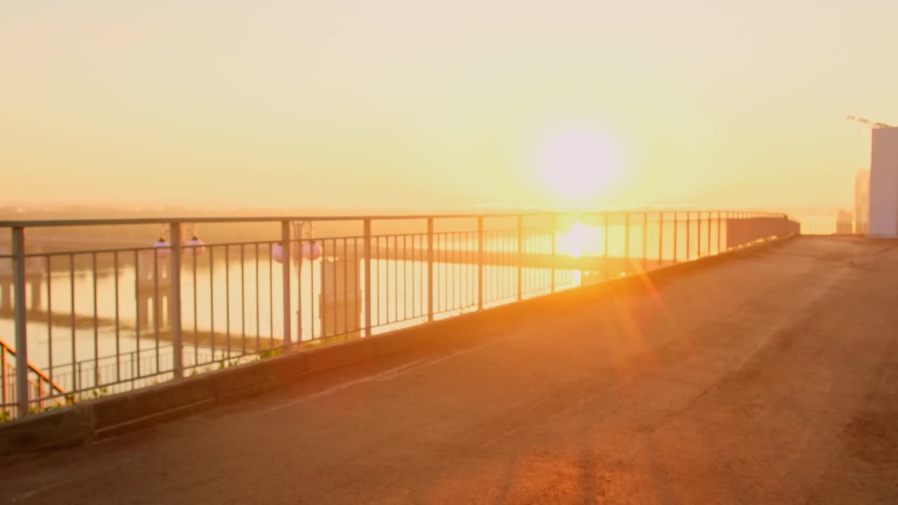 A Vibrant Sunset Overlooking the Water, Capturing a Serene Moment of Reflection and Joyfulness as a Person Walks Towards the Light in a Beautiful Setting