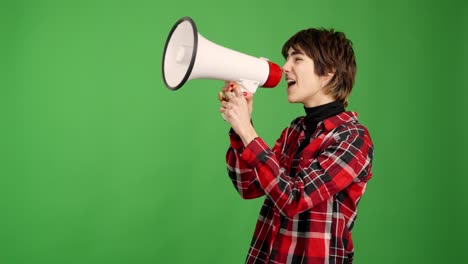 young person speaking into a megaphone on green screen