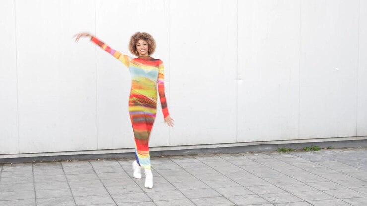 A vibrant fashion statement is made with a colorful dress and joyful dance moves that captivate