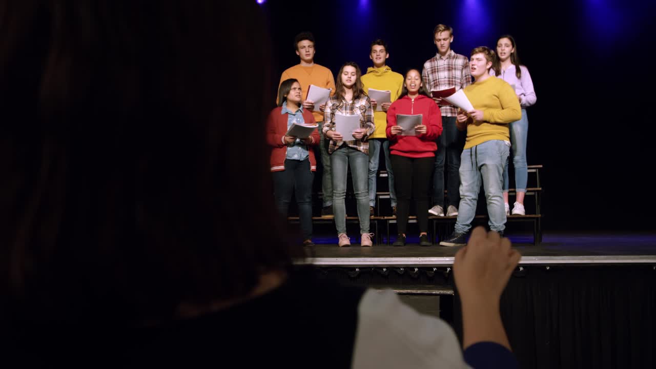 adolescentes ensayando en un teatro