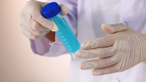 scientist handling test tube with blue liquid