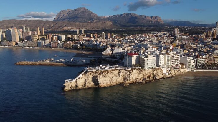 Movimento aereo in avanti verso la costa soleggiata di Benidorm, sulla costa di Levante ad Alicante, Spagna.