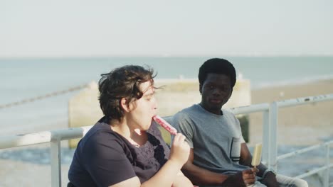 happy young couple with disability eating ice cream at quayside