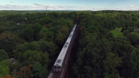 An-aerial-view-of-the-Moodna-Viaduct,-a-steel-railroad-trestle-in-Cornwall,-NY-with-a-train-coming-on-a-sunny-day