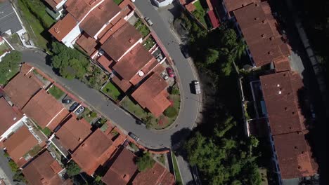 top down shot over housing estate in caracas, venezuela during the quarantine. sunlit, brown rooftops and lush trees and foliage.
