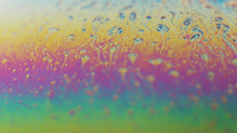 pequeñas partículas abstractas que fluyen hacia la parte superior de una esfera de color arco iris en cámara lenta