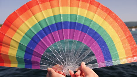 rainbow hand fan at the beach