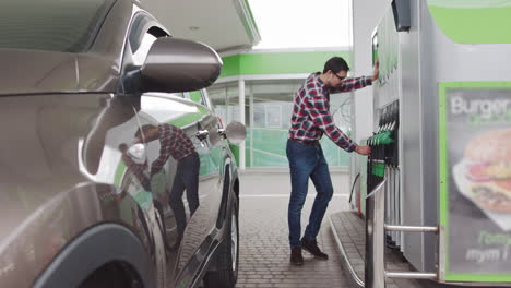 hombre llenando su coche en una gasolinera