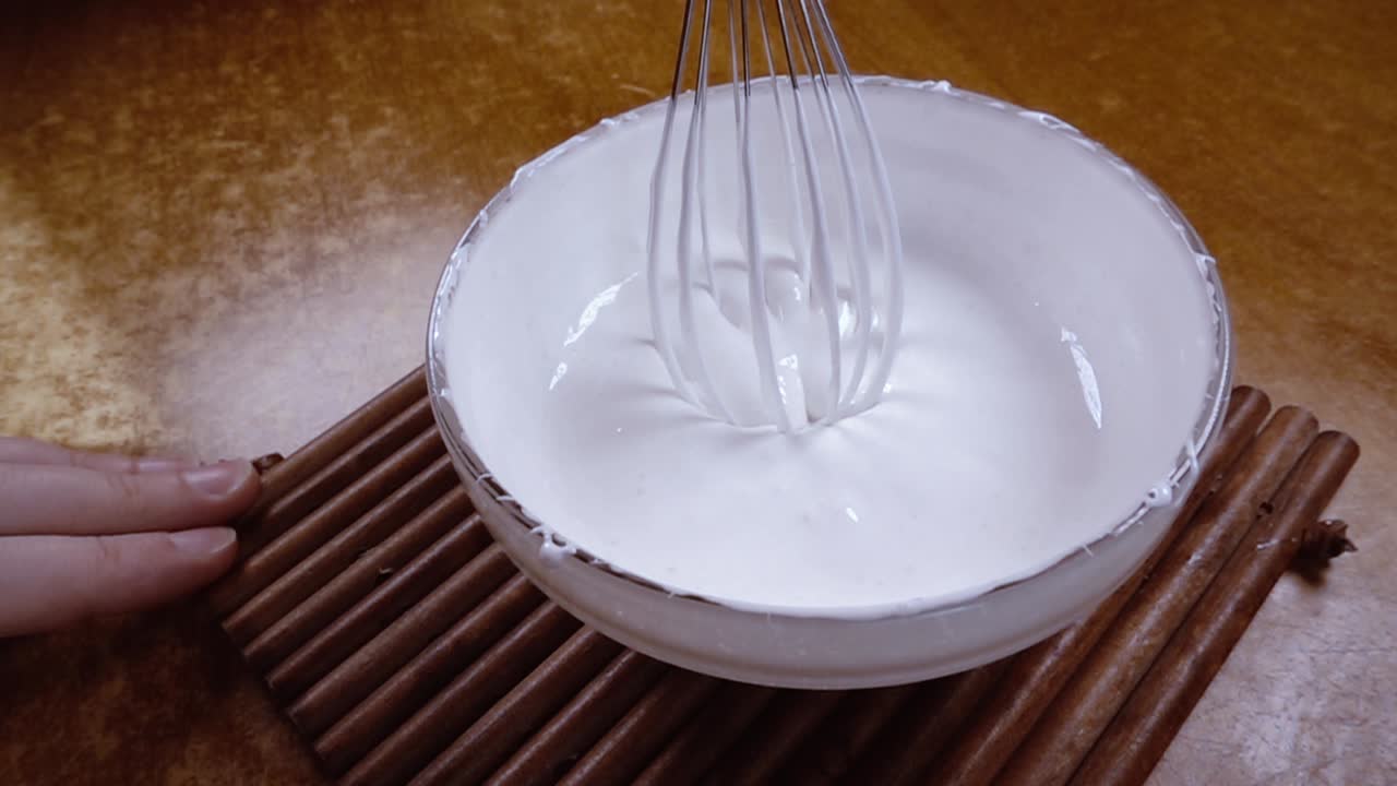 huevos batidos con azúcar usando un mezclador. cámara lenta con disparo de seguimiento de rotación.