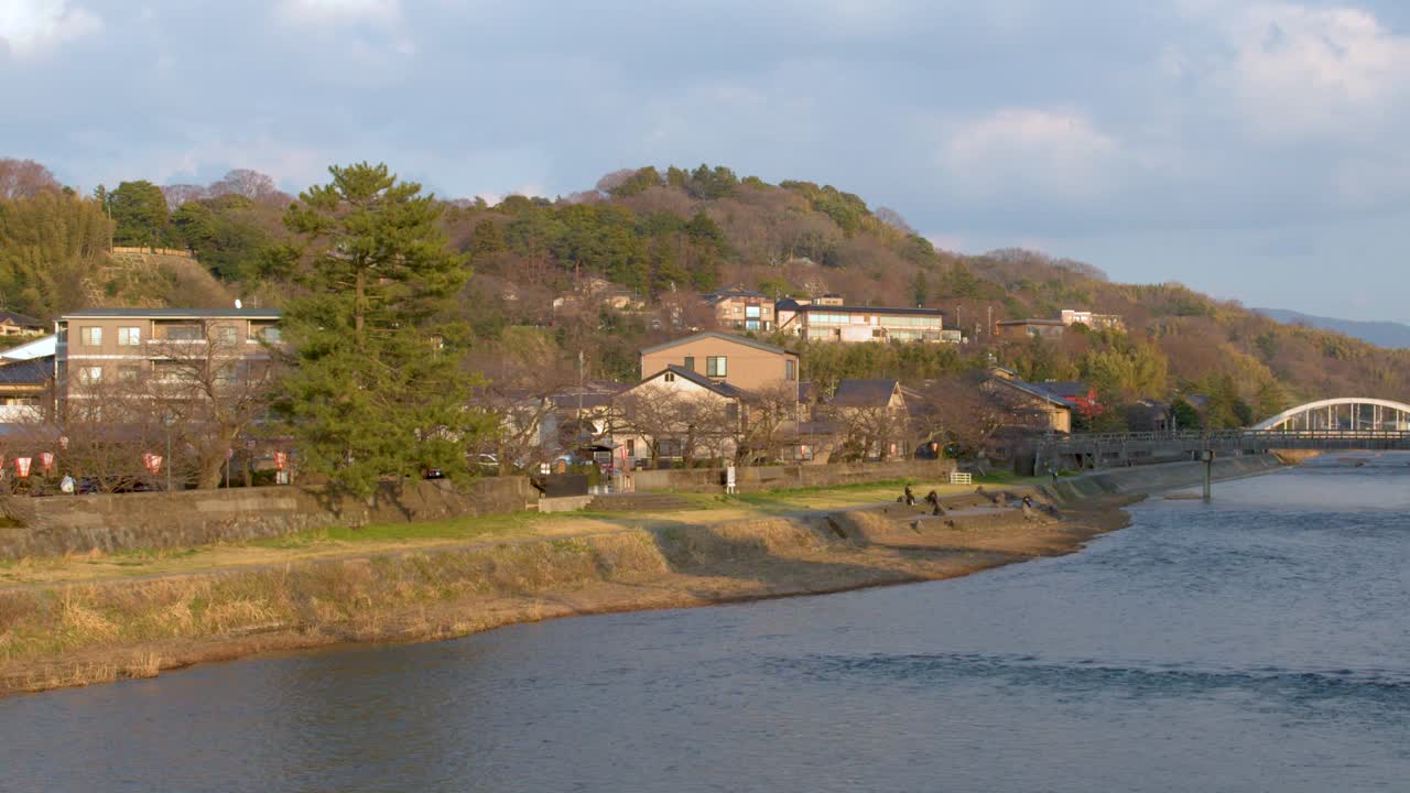 Una lenta panoramica rivela il fiume Asano, l'architettura tradizionale e lussureggianti colline verdi.