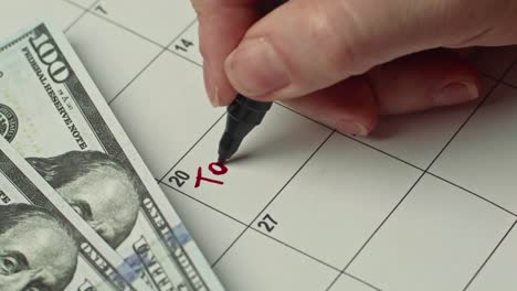 marking tax day date on a calendar with red marker