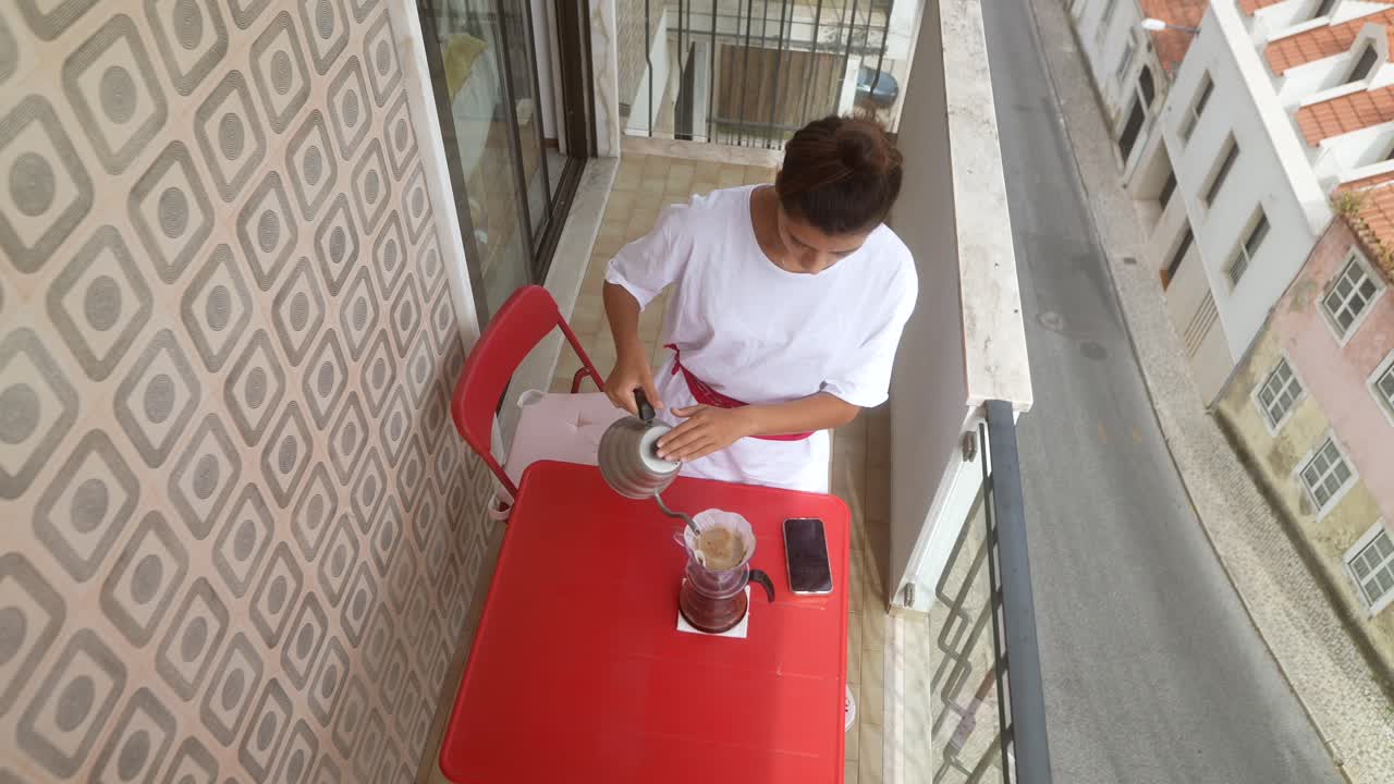 Woman Making Coffee on Balcony