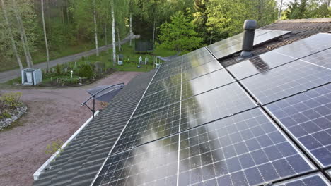 AERIAL-Photovoltaic-cells-generating-electricity-on-a-house-roof,-summer-day