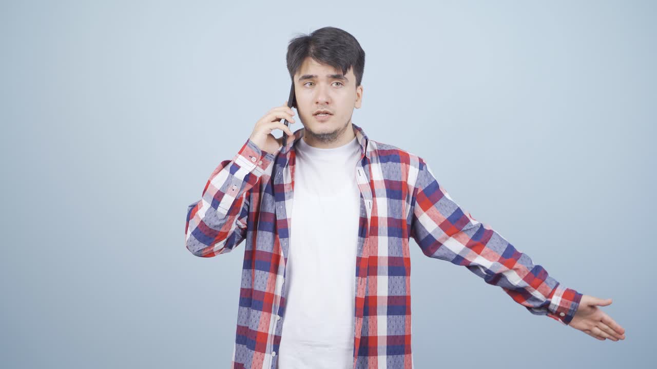 화난 남자가 전화로 얘기하고 있어요.